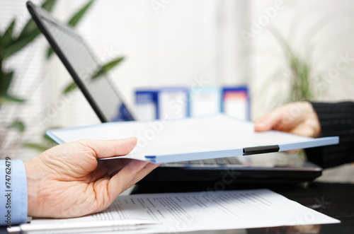 businessman and businesswoman are exchanging document or contrac