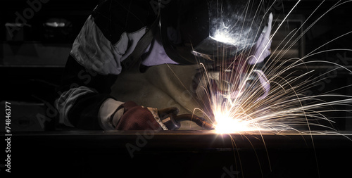 Employee welding steel using MIG/MAG welder.