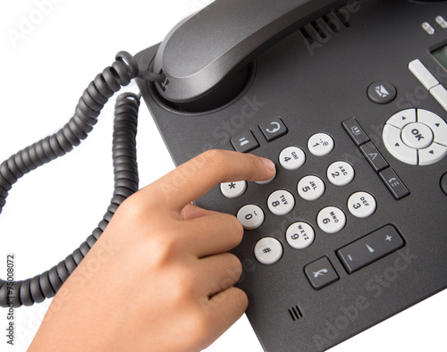 Female hand dialing numbers of desktop telephone 