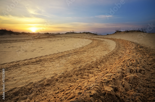 Motocross and auto sport track with sunset sky background.