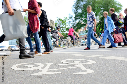 Mixed crowd of pedestrians crossing street and bike lane