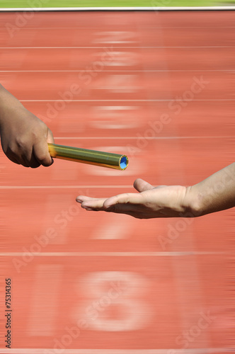  Relay-athletes hands sending action on blur race track startin