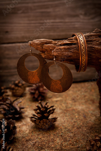 Beautiful gold bracelets and earrings on wooden background