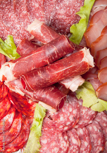 Slices of different kinds of meat with green salad