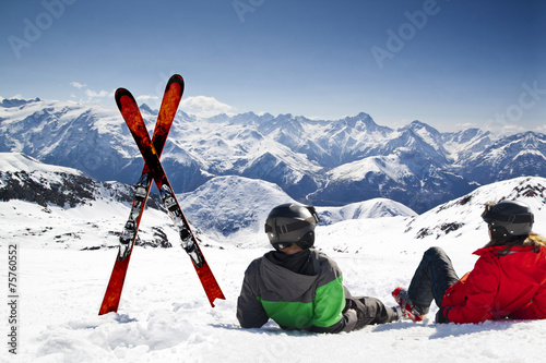 Young happy couple lying in snowy mountains