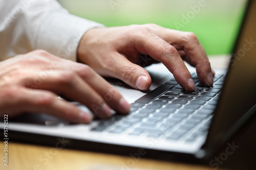 Hands typing on laptop computer