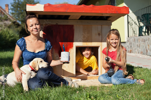 Happy kids painting the doghouse