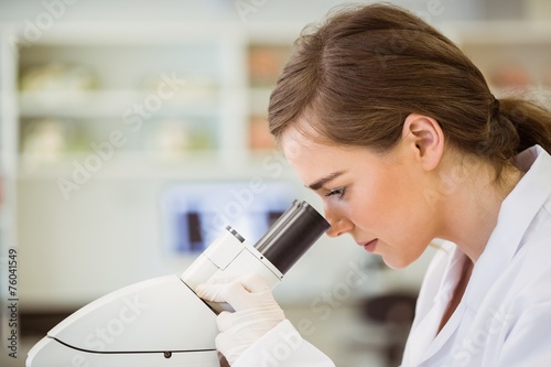 Young scientist working with microscope