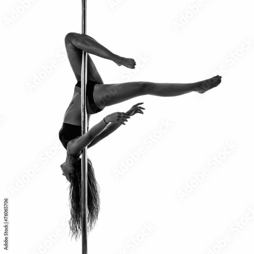 Silouette of woman performing pole dance. Studio shot, black and
