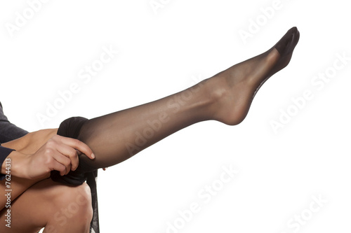 pretty woman puts on her leg nylon stockings