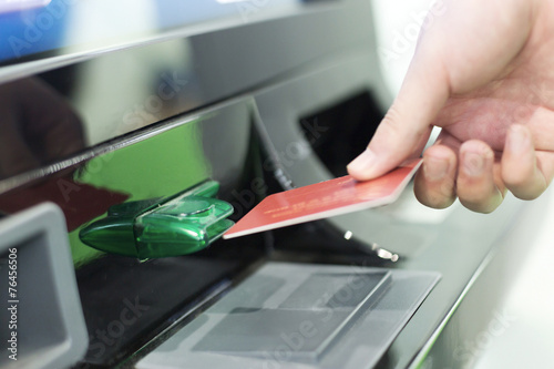 man insert credit card into ATM