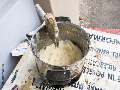 container of glue for paper mache with brush