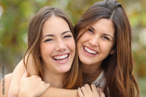 Two women friends laughing with a perfect white teeth