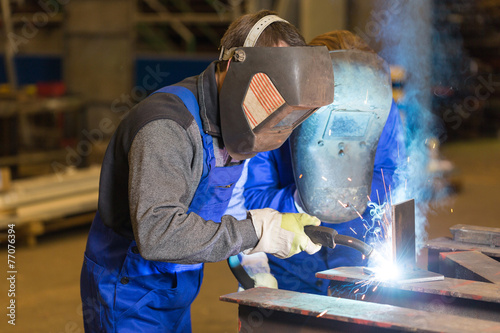 Two steel construction workers welding metal