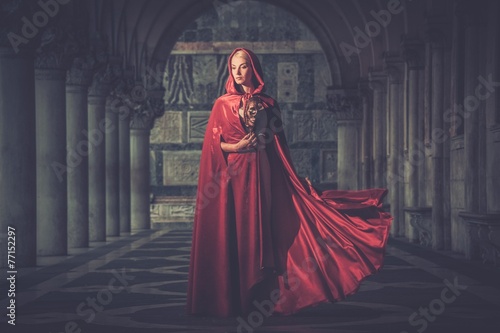 Woman with a mask wearing red cloak outdoor