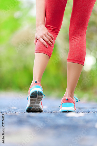 Muscle injury - woman running clutching calf muscle