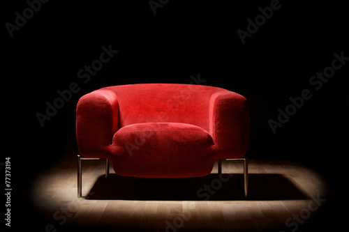 Red alcantara armchair on a black background