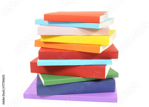 Untidy stack of colorful paperback books isolated white background photo