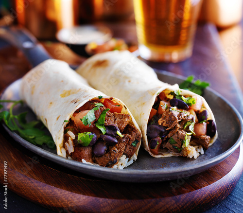 two beef burritos with rice, black beans and salsa