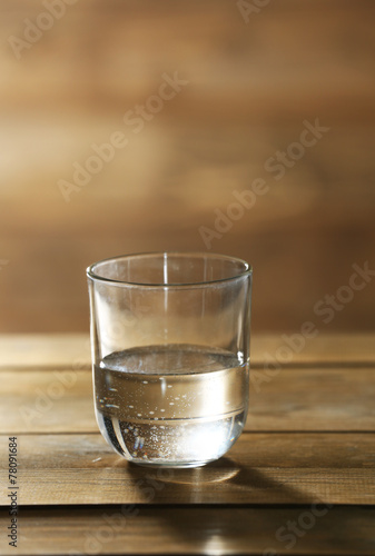 Glass of clean mineral water on rustic wooden background