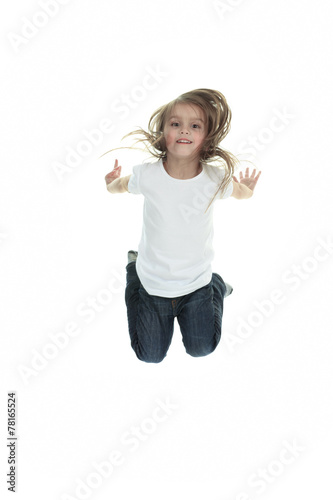 Happy little girl is jumping against white isolated background