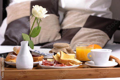 Tray with breakfast on a bed in a hotel room