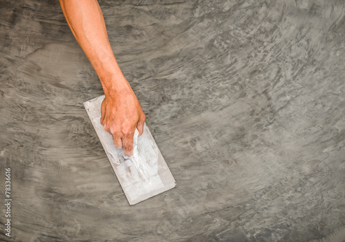 hand using steel trowel to finish Polished wet concrete surface