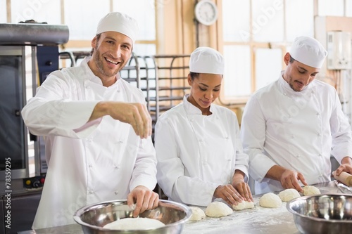 Team of bakers preparing dough