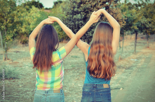 Two best friend girls making a forever sign