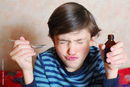 preteen handsome boy make a grimace after taking bitter medicine