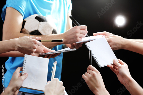 Autographs by football star on black and lights background