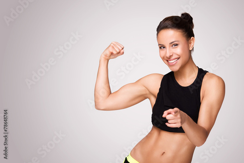 Mixed race woman demonstrating biceps