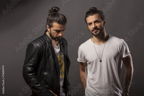 Two handsome young men with a beard and long hair in a bun
