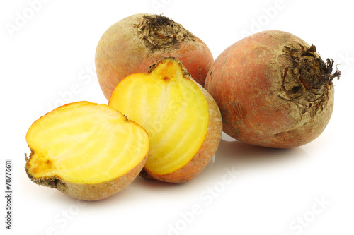 freshly harvested yellow beet and two halves on a white backgrou