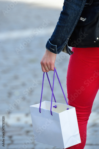 Woman in red on street with shopping bag