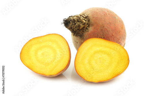 freshly harvested yellow beet and two halves on a white backgrou