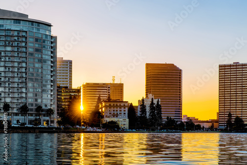 Oakland Lake Merritt skyline backlit at sunset with sun flare be