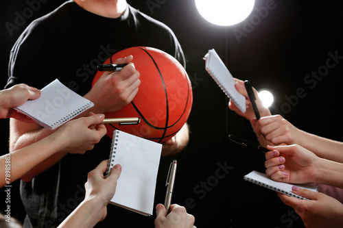 Autographs by basketball star on black and lights background