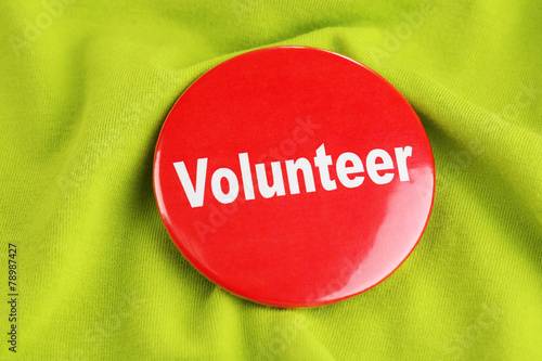 Round volunteer button on cloth background