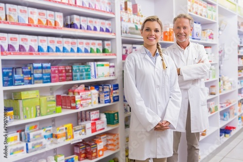 Pharmacist with his trainee standing and smiling at camera