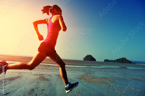 young woman running on sunrise beach 