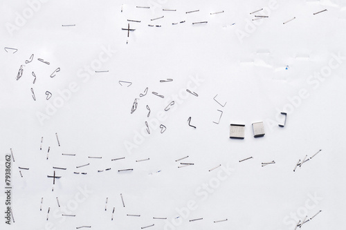 White piece of paper with staple needles.