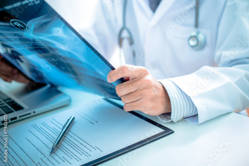 close up of male doctor holding x-ray or roentgen image