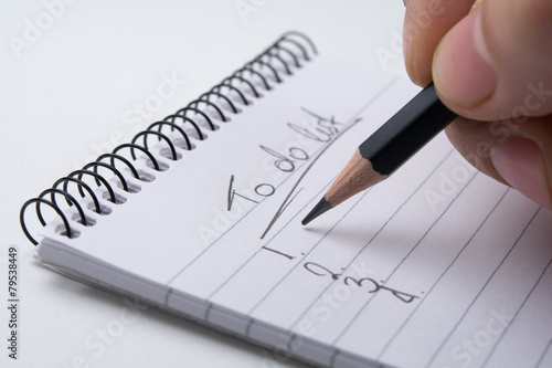 Close up of hand holding a pencil and writes the to do list