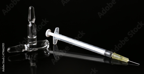 Ampules with syringe on black background