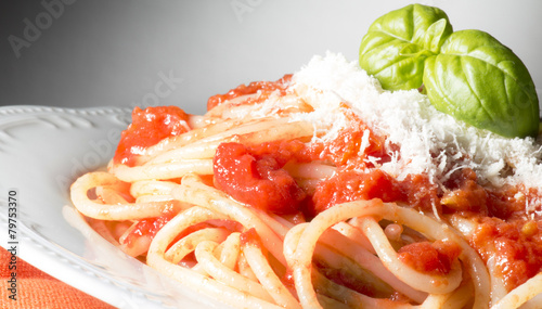 dish with spaghetti and tomato sauce on the wooden table