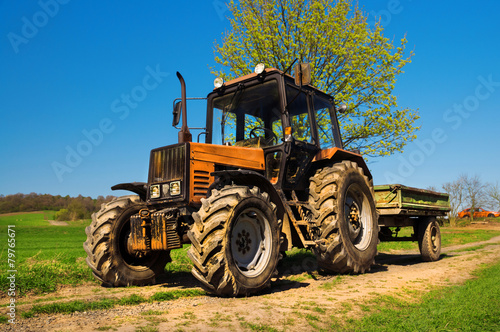 Red rusty tractor on a field