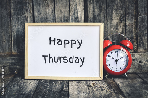 Happy Thursday message on white board and red retro clock by wo