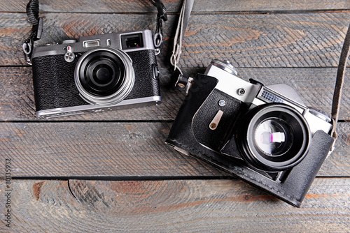 Old retro cameras on rustic wooden planks background