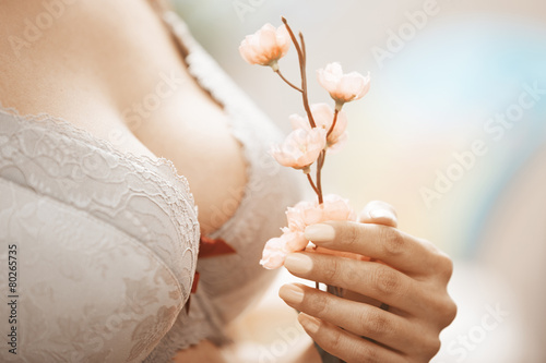 Woman in brassiere holding Sakura flower